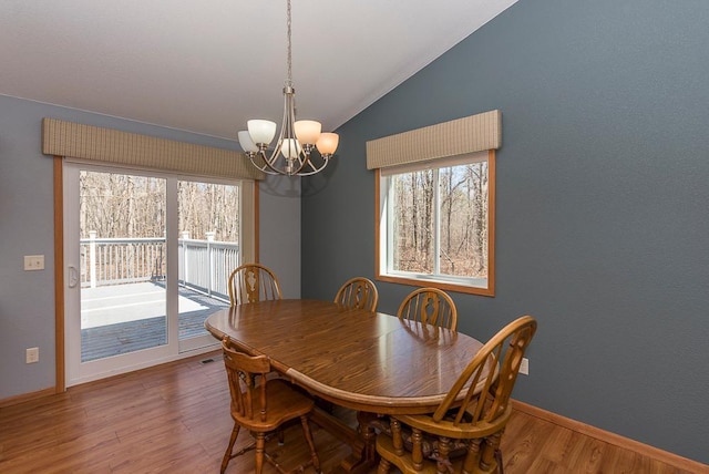 10098 Pin Oak Ln, Brainerd, MN 56401 - dining area featuring an inviting chandelier, baseboards, lofted ceiling, and wood finished floors