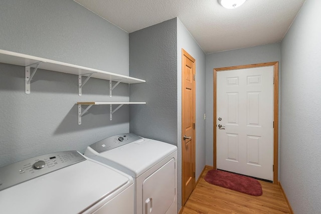 10098 Pin Oak Ln, Brainerd, MN 56401 - clothes washing area featuring laundry area, a textured wall, washer and clothes dryer, and light wood finished floors