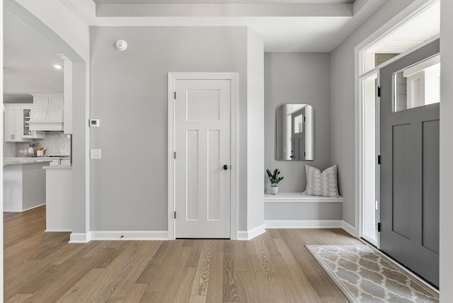 entryway with light wood finished floors and baseboards
