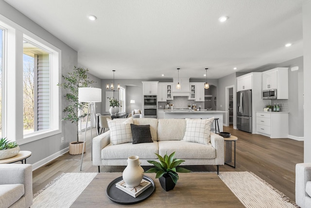 living area with recessed lighting, baseboards, plenty of natural light, and wood finished floors
