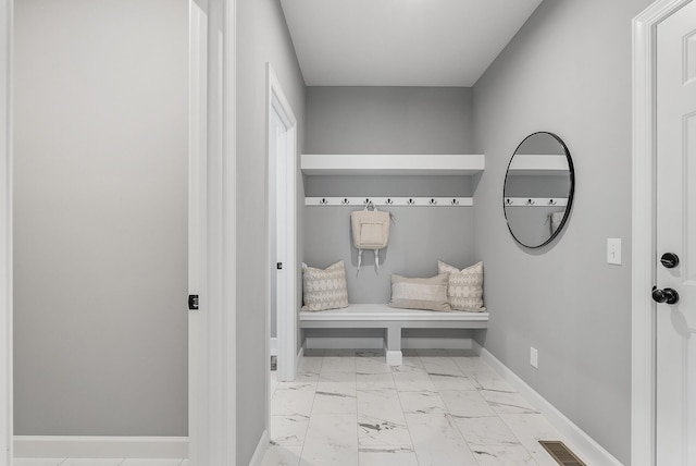 mudroom with marble look tiles and baseboards