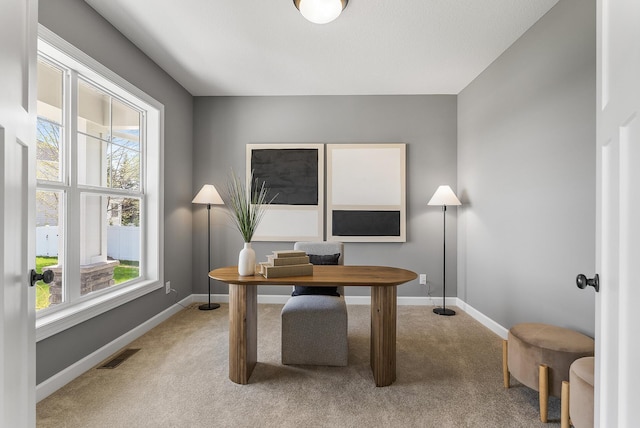 office area featuring light carpet and baseboards