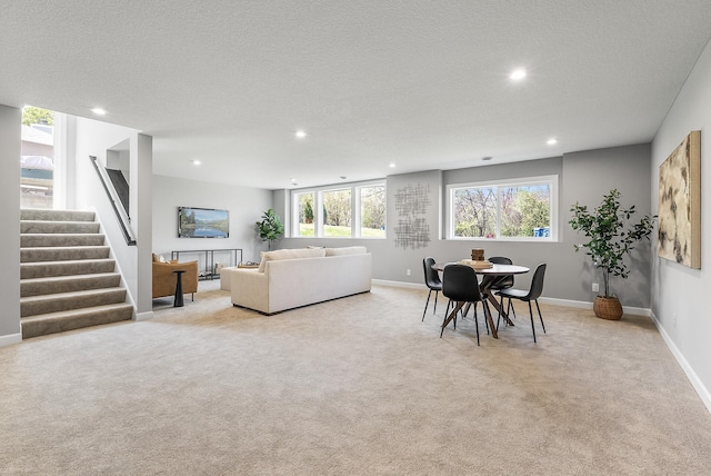 living room featuring recessed lighting, light colored carpet, stairway, baseboards, and a textured ceiling
