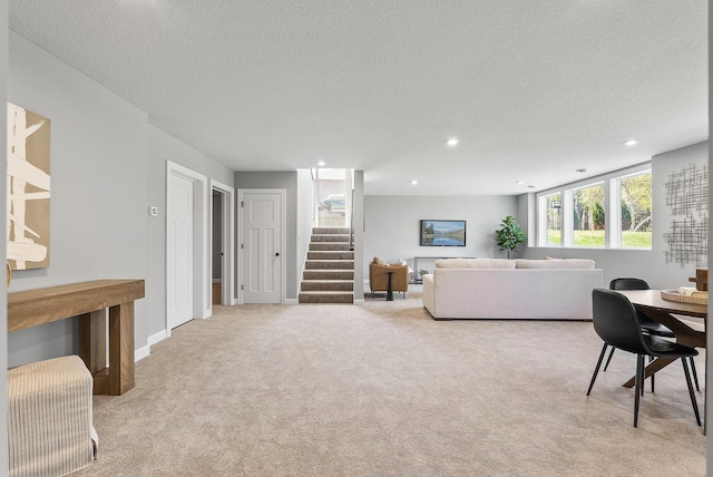living room featuring stairs, light colored carpet, a textured ceiling, and recessed lighting