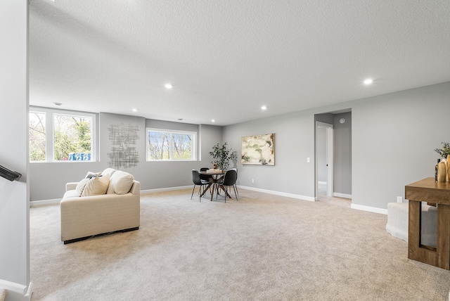 living room featuring light carpet, a textured ceiling, recessed lighting, and baseboards