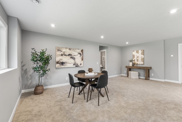 dining space with recessed lighting, light colored carpet, and baseboards