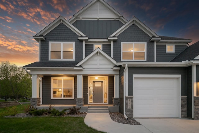 craftsman house featuring a porch, stone siding, driveway, and an attached garage