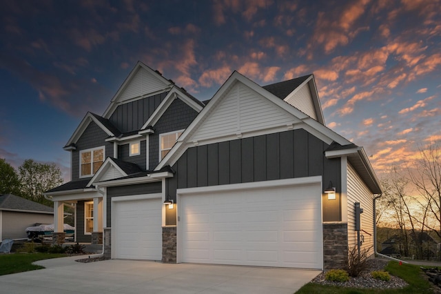 view of front of home with stone siding, board and batten siding, concrete driveway, and an attached garage
