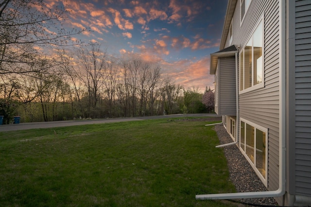 yard at dusk featuring a yard