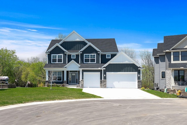 craftsman inspired home with board and batten siding, concrete driveway, stone siding, a front yard, and an attached garage