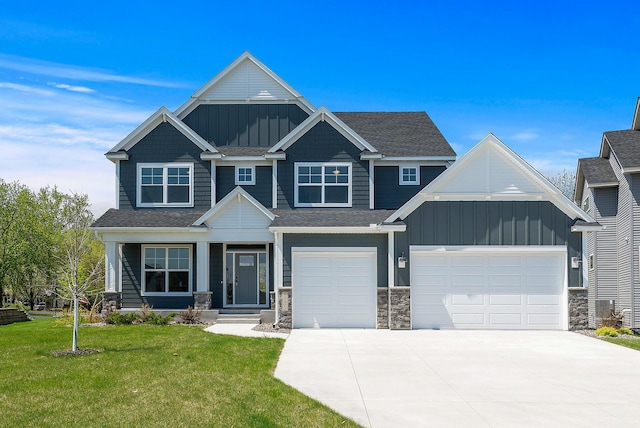 craftsman-style house with board and batten siding, concrete driveway, a front yard, and stone siding