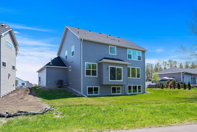 rear view of property featuring a lawn and central AC unit