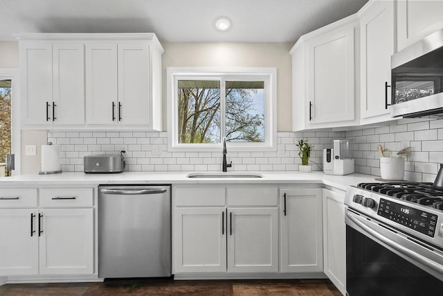 kitchen featuring a sink, white cabinetry, backsplash, and appliances with stainless steel finishes