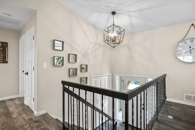 stairs with baseboards, an inviting chandelier, visible vents, and wood finished floors
