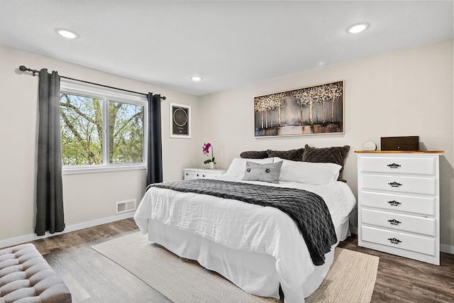 bedroom featuring dark wood finished floors, visible vents, and baseboards