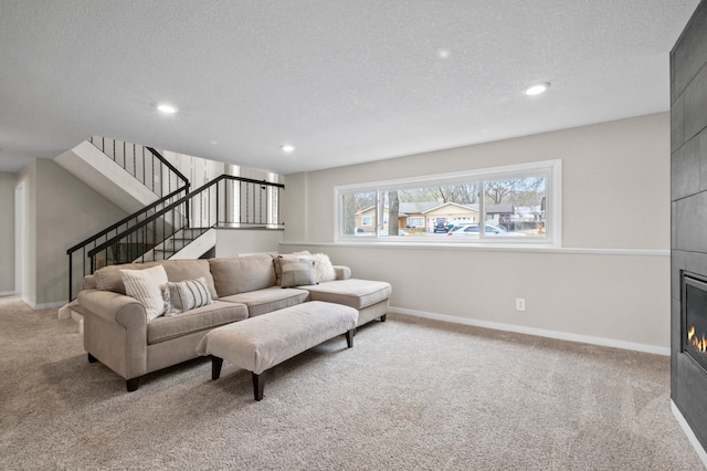 carpeted living area with stairs, a textured ceiling, recessed lighting, a fireplace, and baseboards