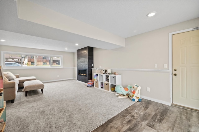 recreation room with baseboards, a tile fireplace, recessed lighting, and wood finished floors