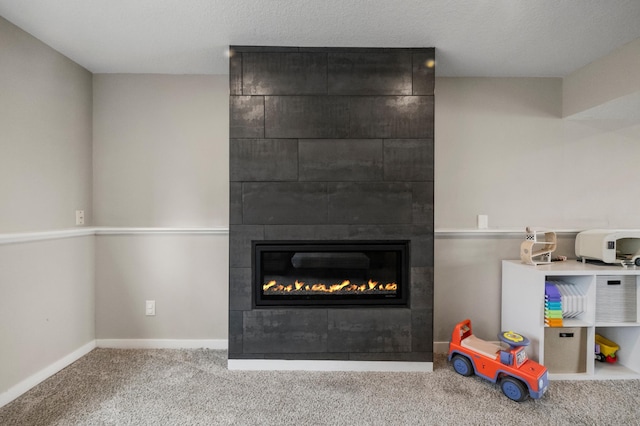 playroom featuring baseboards, carpet flooring, and a large fireplace