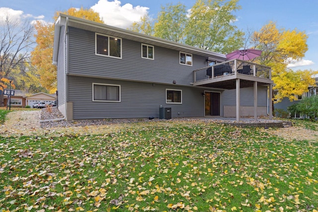 back of property with central air condition unit and a yard