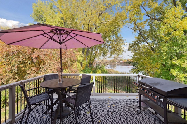 wooden deck featuring a water view and outdoor dining space