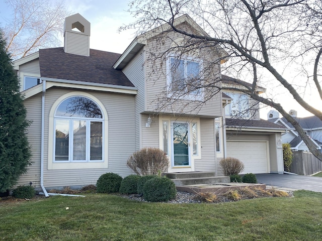 view of front facade with driveway, a chimney, roof with shingles, a front lawn, and an attached garage