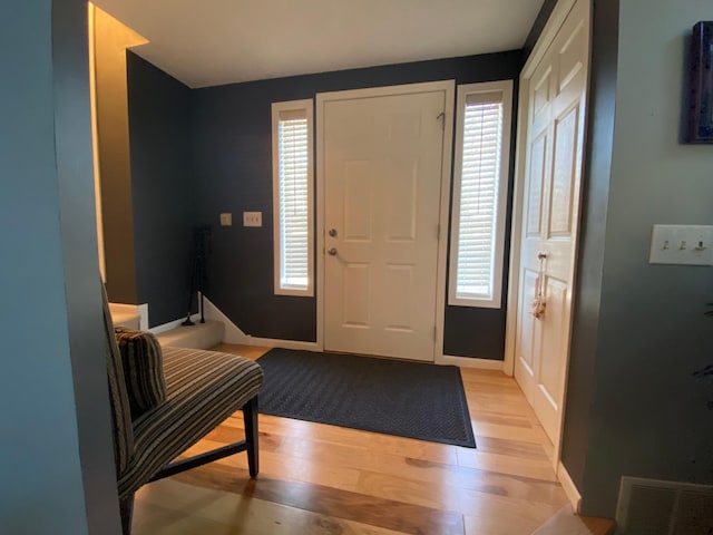 foyer with baseboards, visible vents, plenty of natural light, and light wood-type flooring