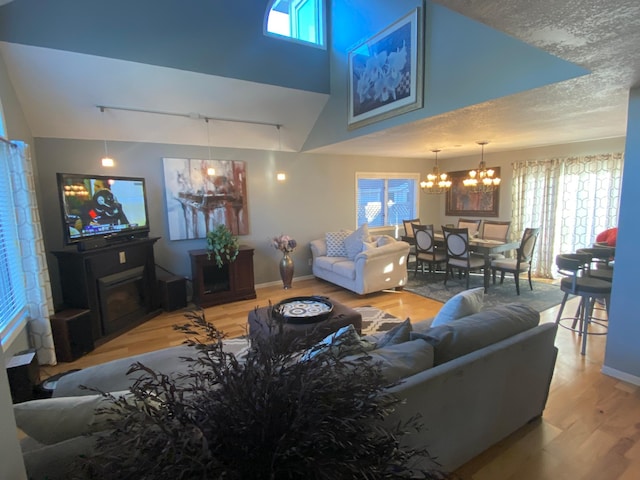 living area with plenty of natural light, wood finished floors, and a notable chandelier