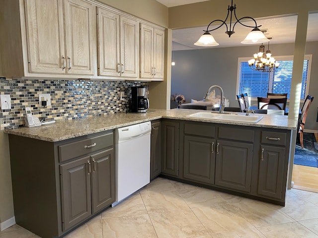 kitchen featuring tasteful backsplash, dishwasher, a sink, gray cabinetry, and a peninsula