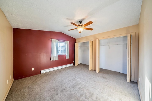 unfurnished bedroom with carpet floors, a ceiling fan, lofted ceiling, two closets, and a baseboard radiator