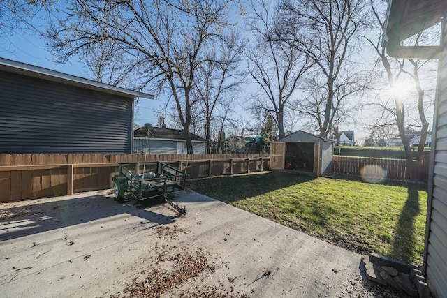 view of yard featuring a fenced backyard, an outbuilding, a shed, and a patio