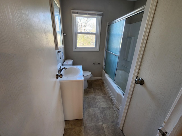 full bath featuring vanity, baseboards, bath / shower combo with glass door, and toilet