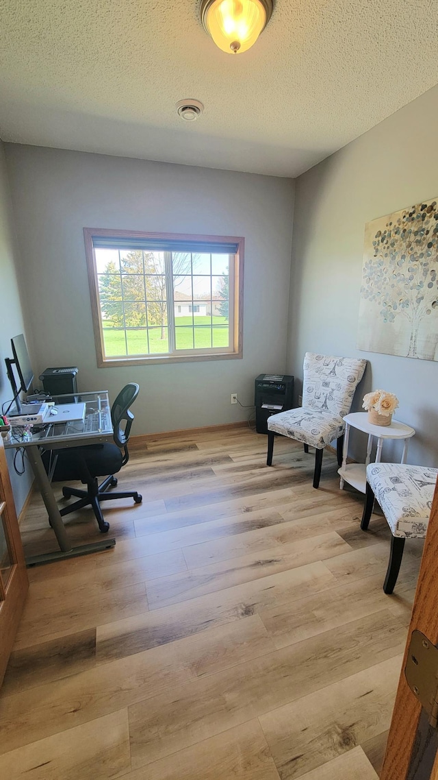 office with visible vents, a textured ceiling, and wood finished floors