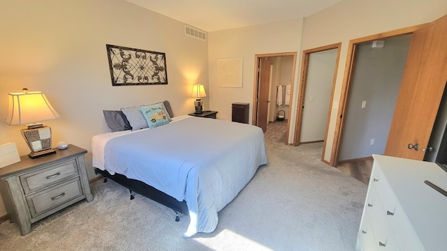 bedroom with visible vents and light carpet