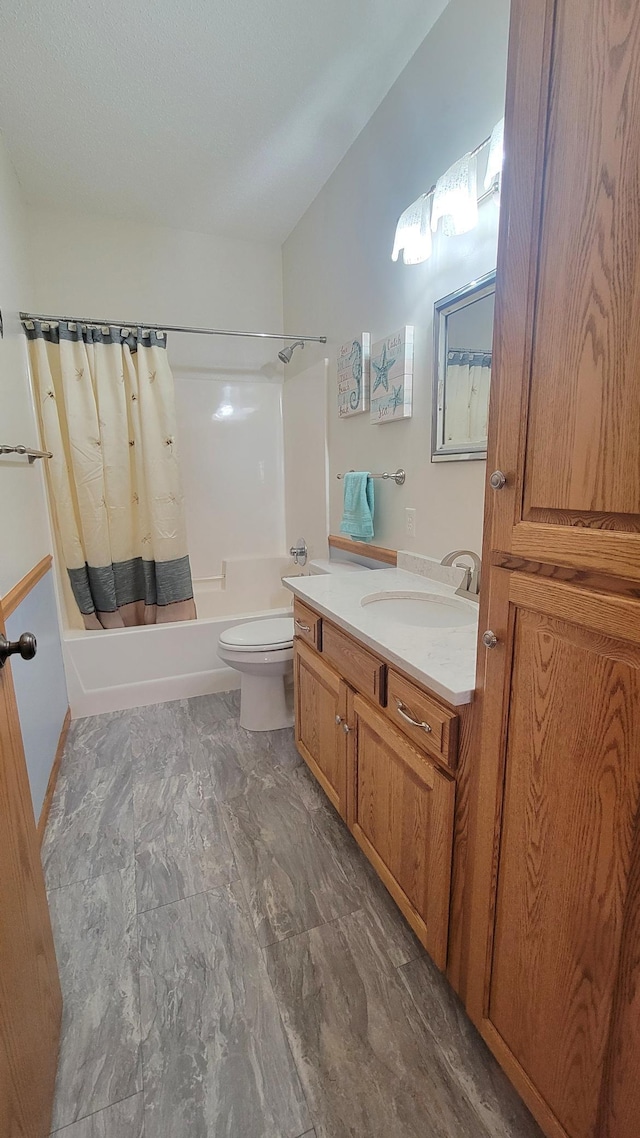 bathroom featuring vanity, toilet, marble finish floor, and shower / tub combo