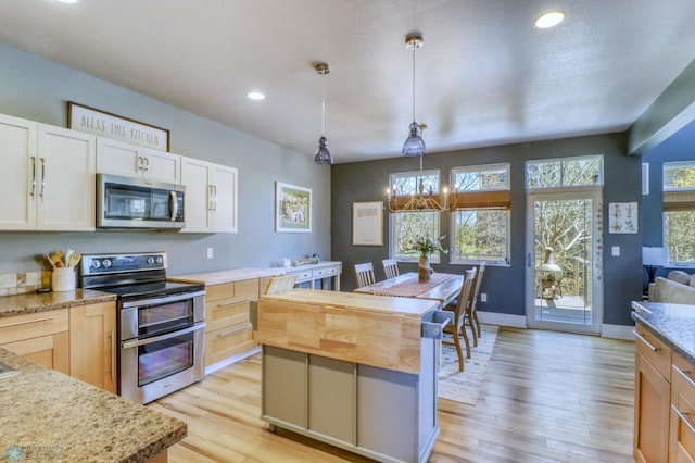 kitchen with a kitchen island, light wood-type flooring, recessed lighting, white cabinetry, and stainless steel appliances