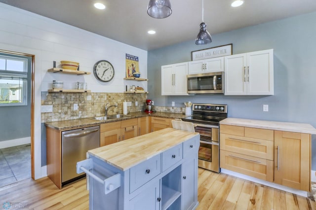 kitchen featuring open shelves, appliances with stainless steel finishes, a sink, wooden counters, and white cabinetry