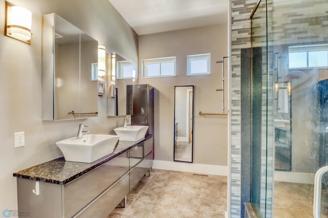 bathroom with a sink, a healthy amount of sunlight, and a shower stall