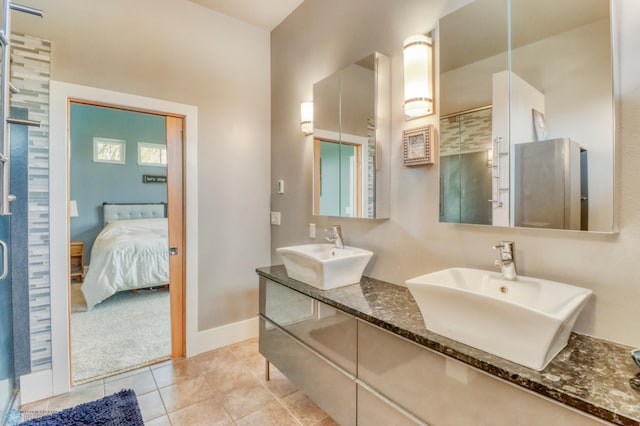 full bath featuring ensuite bathroom, a sink, tile patterned floors, and a shower stall
