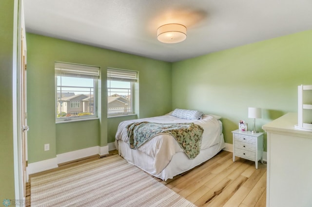 bedroom with baseboards and wood finished floors