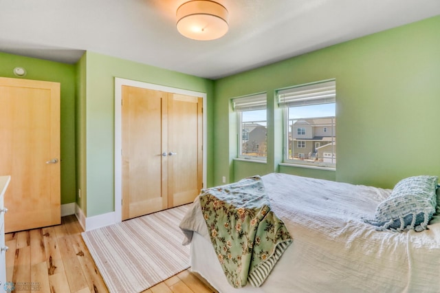 bedroom featuring a closet, baseboards, and wood finished floors