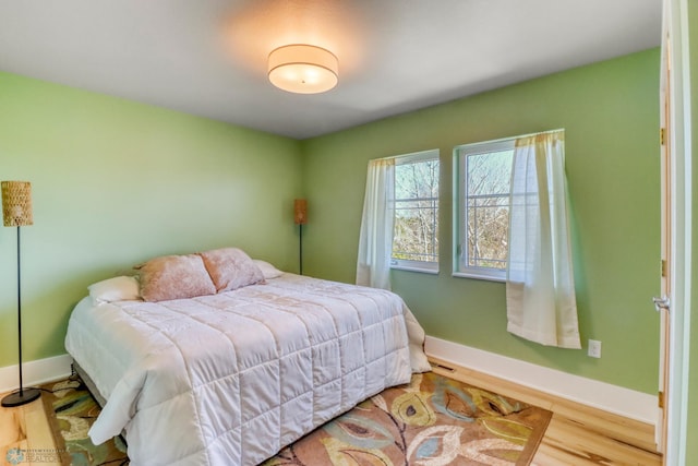 bedroom featuring baseboards and wood finished floors