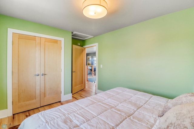 bedroom featuring baseboards, attic access, and wood finished floors