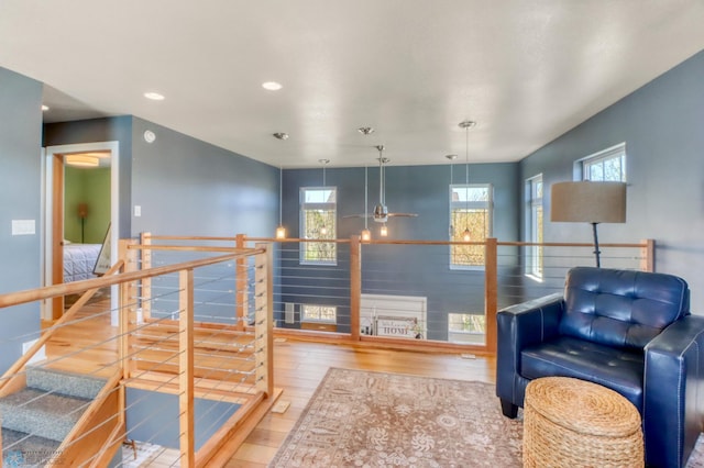 living area with recessed lighting, a ceiling fan, an upstairs landing, and hardwood / wood-style floors
