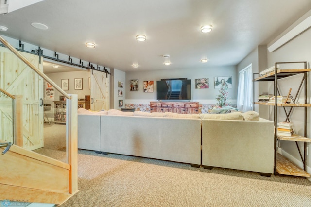 living area with a barn door and carpet