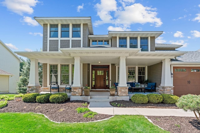 view of front of house featuring a porch, stone siding, and a garage