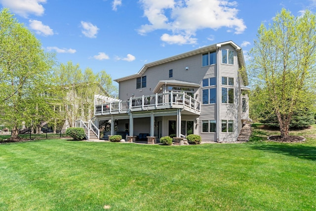 rear view of property featuring a deck, stairway, and a lawn