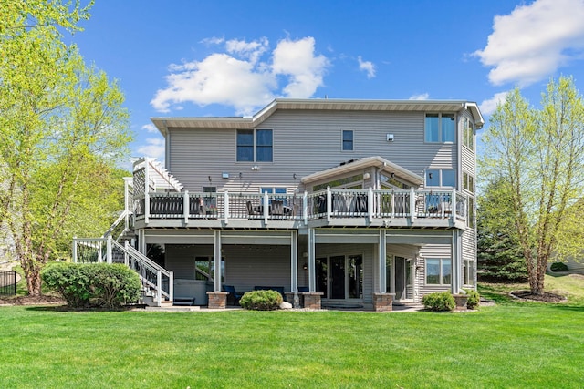 rear view of property featuring a deck, a lawn, and stairs