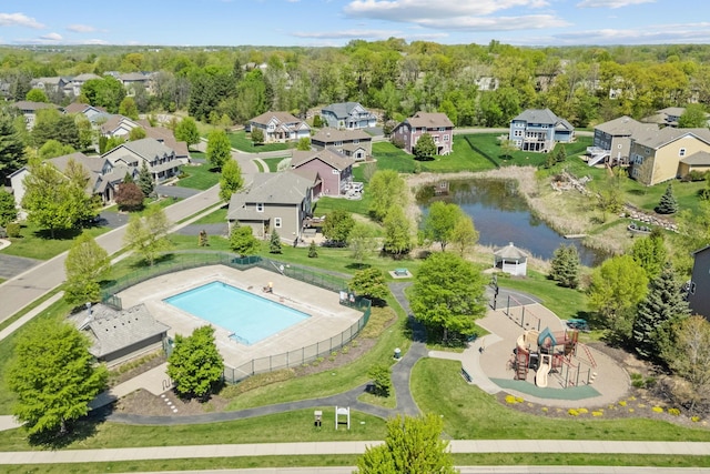 aerial perspective of suburban area with a large body of water and a pool