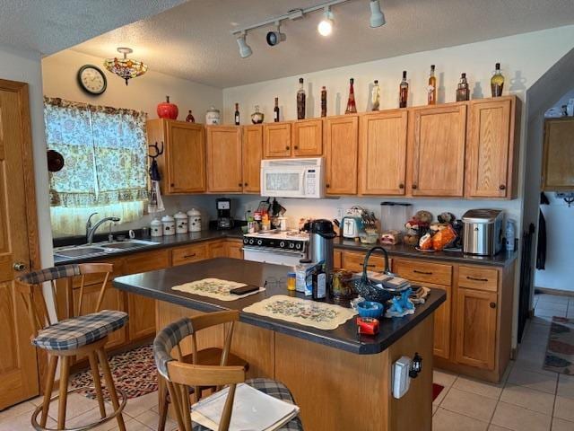 40171 Clitherall Lake Rd, Clitherall Twp, MN 56524 - kitchen featuring dark countertops, stove, a sink, light tile patterned floors, and white microwave