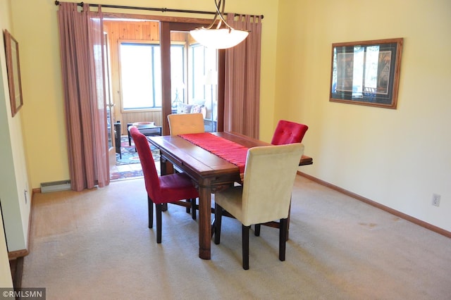 carpeted dining area featuring baseboards